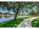 Peaceful waterfront walkway shaded by a large tree at 1408 Riverside Dr, Tarpon Springs, FL 34689