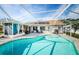 Backyard view of screened-in pool with a paved patio and solar panels on the roof at 1575 Wicklow Dr, Palm Harbor, FL 34684