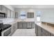 Modern kitchen with gray cabinets, stainless steel appliances, and white subway tile at 4214 Duck Creek Way, Ellenton, FL 34222