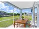 Screened porch with wooden dining set and backyard view at 4214 Duck Creek Way, Ellenton, FL 34222