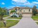 Tan two-story house with a paved driveway and palm trees at 1509 Riverside Dr, Tarpon Springs, FL 34689