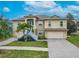 Tan two-story house with a large driveway and palm trees at 1509 Riverside Dr, Tarpon Springs, FL 34689