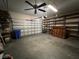 Two-car garage with built-in shelving and ceiling fan at 3619 Springville Dr, Valrico, FL 33596