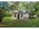 Small brick guest house with a dark blue door and a red bench at 37439 Meridian Ave, Dade City, FL 33525