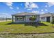 Back exterior view of the home with a covered patio and green lawn at 11826 Richmond Trl, Parrish, FL 34219