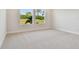 Bright bedroom with neutral carpeting, and a view of palm trees visible from the windows at 11826 Richmond Trl, Parrish, FL 34219
