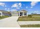 Inviting single-story home with a well-maintained lawn, gray paint, and an attached two-car garage at 11826 Richmond Trl, Parrish, FL 34219