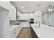 Kitchen featuring stainless steel appliances, quartz countertops, white cabinetry and a large center island at 11826 Richmond Trl, Parrish, FL 34219