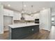 Bright kitchen featuring a large island with seating, quartz countertops, stainless steel appliances, and white cabinets at 11826 Richmond Trl, Parrish, FL 34219