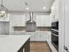 Modern kitchen featuring stainless steel appliances, quartz countertops, white cabinets, and a center island at 11826 Richmond Trl, Parrish, FL 34219