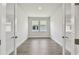 Empty office space featuring wood-look floors, white walls, and two windows providing natural light at 11826 Richmond Trl, Parrish, FL 34219