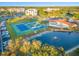 Aerial view showing tennis courts, pool, pond, and buildings at 125 Mariner Dr # 125, Tarpon Springs, FL 34689