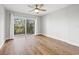 Bedroom with hardwood floors, sliding glass door to balcony at 125 Mariner Dr # 125, Tarpon Springs, FL 34689