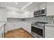 Modern kitchen with white cabinets, stainless steel appliances, and granite countertops at 125 Mariner Dr # 125, Tarpon Springs, FL 34689