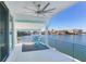 A waterfront balcony features a ceiling fan, tiled floor, and railing with serene views of the water and coastal homes at 17410 1St E St, Redington Shores, FL 33708