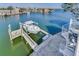 Waterfront home featuring a private dock with a boat lift and a spiral staircase at 17410 1St E St, Redington Shores, FL 33708
