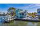 Beautifully landscaped waterfront home featuring a private dock, boat, outdoor lounge and a multi-level terrace at 17410 1St E St, Redington Shores, FL 33708