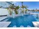 Beautiful pool with water features, mosaic tile accents, and lush tropical landscaping creating a backyard oasis at 17410 1St E St, Redington Shores, FL 33708
