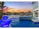 Twilight view of a pool with water features, mosaic tile accents, and waterfront views at 17410 1St E St, Redington Shores, FL 33708
