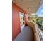 Corner view of the balcony with painted terracotta-colored walls, neutral railing, and partial tree views at 2021 Shangrila Dr # 60, Clearwater, FL 33763