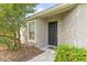 Front entry of the house with a black door and landscaping at 4427 Ashton Meadows Way, Wesley Chapel, FL 33543