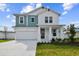 Two-story home with white and teal siding, and a landscaped front yard at 709 W Orient St, Tampa, FL 33603