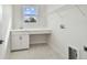 Bright laundry room with white cabinets, shelving, and window at 709 W Orient St, Tampa, FL 33603