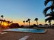 Inviting community pool at sunset with lounge chairs at 1480 Gulf Blvd # 1107, Clearwater Beach, FL 33767