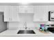 Modern kitchen with white cabinets and a farmhouse sink at 4444 Swift Rd # 20, Sarasota, FL 34231