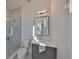 Bathroom with a glass-enclosed shower, gray vanity, modern mirror, and tiled floor at 4608 S Ferdinand Ave, Tampa, FL 33611