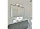 Modern bathroom features a gray vanity with a large framed mirror and ample lighting at 4608 S Ferdinand Ave, Tampa, FL 33611