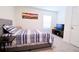 Bedroom with striped bedding and a large wall-mounted TV at 12113 Water Ash Pl, Riverview, FL 33569