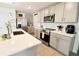 Modern kitchen featuring stainless steel appliances, gray cabinets, and white quartz countertops at 12113 Water Ash Pl, Riverview, FL 33569
