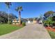 Single-story home with a stone facade, driveway, and palm trees at 4147 Marine Pkwy, New Port Richey, FL 34652