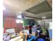 View of a cluttered garage with overhead door and storage at 7521 Coventry Dr, Port Richey, FL 34668