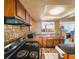 Kitchen with wood cabinets, black stove and tin backsplash at 7521 Coventry Dr, Port Richey, FL 34668