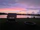 Serene lakefront view at sunset, featuring a fire pit and swing at 708 Fern Leaf Dr, Ruskin, FL 33570