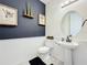 Modern powder room with pedestal sink and dark blue walls at 5935 Maidenstone Way, Palmetto, FL 34221
