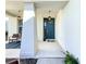Front porch with a teal front door and two wicker chairs at 5935 Maidenstone Way, Palmetto, FL 34221