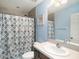 Clean bathroom with shower/tub combo and patterned shower curtain at 9107 Brunswick Ln, Tampa, FL 33615