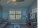 Light-filled living room with large window, comfortable seating, and flat-screen TV at 9107 Brunswick Ln, Tampa, FL 33615