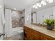 Updated bathroom featuring tiled shower, granite countertop, and wooden vanity at 16308 Gulf Blvd # 303, Redington Beach, FL 33708