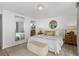 Bedroom featuring a decorative mirror, a round wall mirror and neutral colors at 16308 Gulf Blvd # 303, Redington Beach, FL 33708