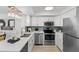 Stylish kitchen with stainless steel appliances, subway tile backsplash, and modern lighting at 16308 Gulf Blvd # 303, Redington Beach, FL 33708