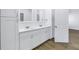 Bathroom featuring a double sink vanity with white cabinets, quartz countertops, wood-look flooring, and modern fixtures at 1521 Preston S St, St Petersburg, FL 33712