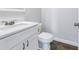 A bathroom featuring white cabinets, a sleek countertop, and modern toilet at 1521 Preston S St, St Petersburg, FL 33712