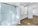 Bathroom featuring a walk-in shower, double sink vanity with white cabinets, quartz countertops, wood-look flooring, and modern fixtures at 1521 Preston S St, St Petersburg, FL 33712