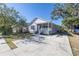 Inviting home with a covered front porch and wide driveway, surrounded by lush greenery at 1521 Preston S St, St Petersburg, FL 33712