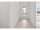 Hallway with a front door with glass inserts and tile floors leading into other rooms at 17203 Luminous Ave, Venice, FL 34293
