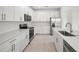 Bright kitchen with stainless steel appliances, white cabinetry, and stone countertops at 17203 Luminous Ave, Venice, FL 34293